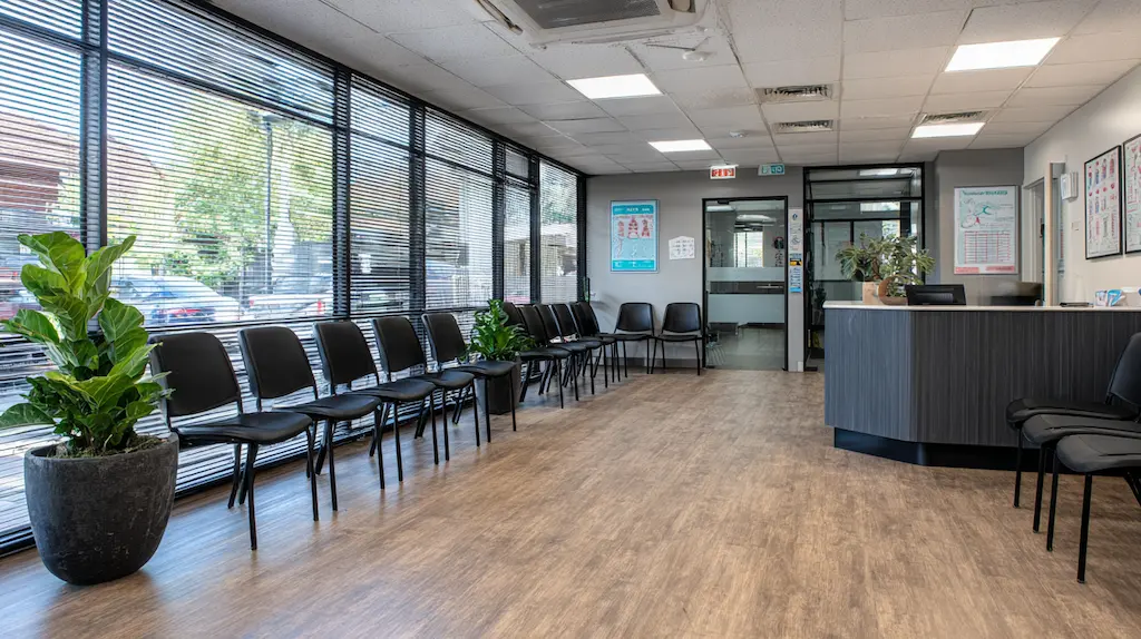 Spotless clean Australian medical centre waiting room with rows of black chairs and reception desk
